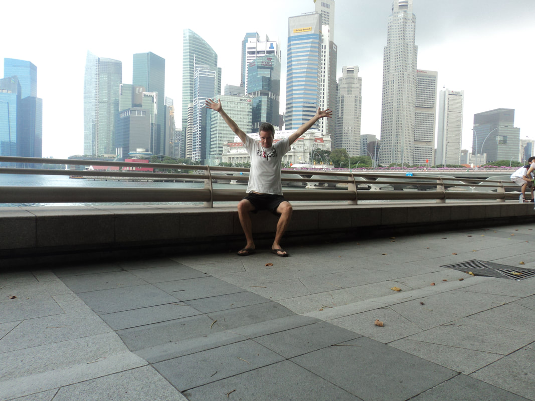 Nomadic Backpacker in Singapore with city skyline behind