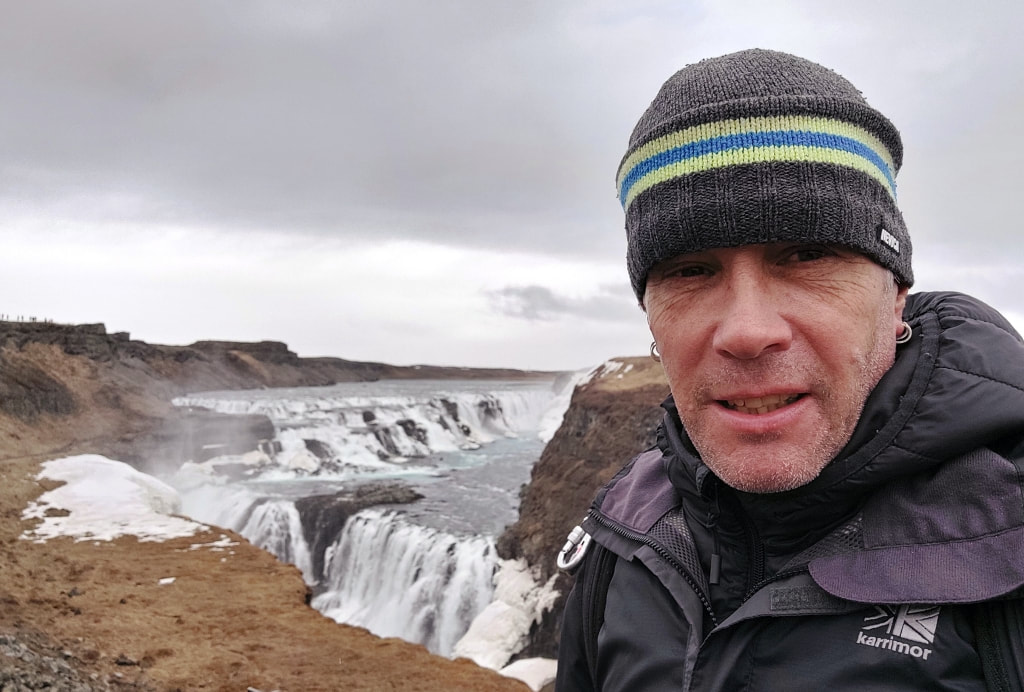 Nomadic backpacker with the Gullfoss waterfall behind