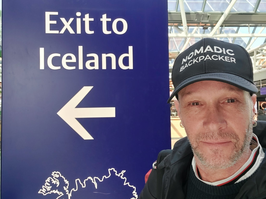 posing in front of the Iceland sign