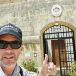 Visiting the Sovereign Military Order of Malta | The Country with No Land Nomadic Backpacker at the entrance to the Sovereign Military Order of Malta at Fort St Angelo