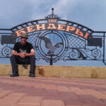 Nomadic Backpacker with the sign for Бендеры / Bender behind