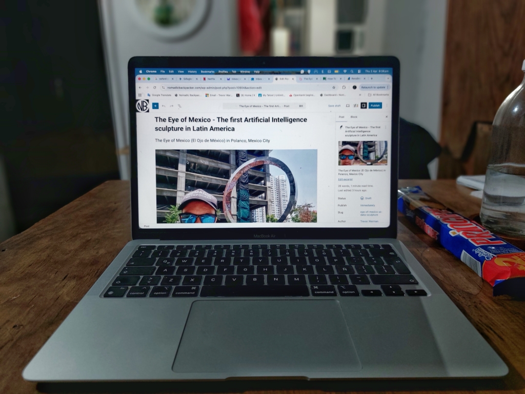 Nomadic Backpacker travel blogger on a MacBook Air laptop.