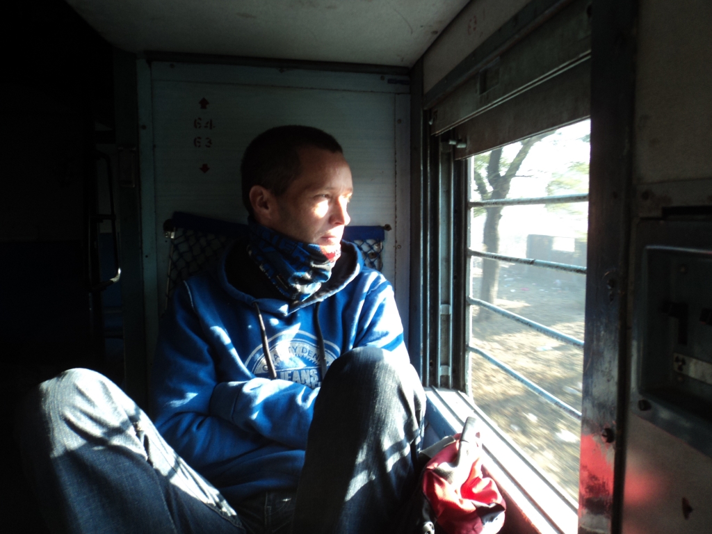 Nomadic Backpacker travelling by train, looking through barred windows